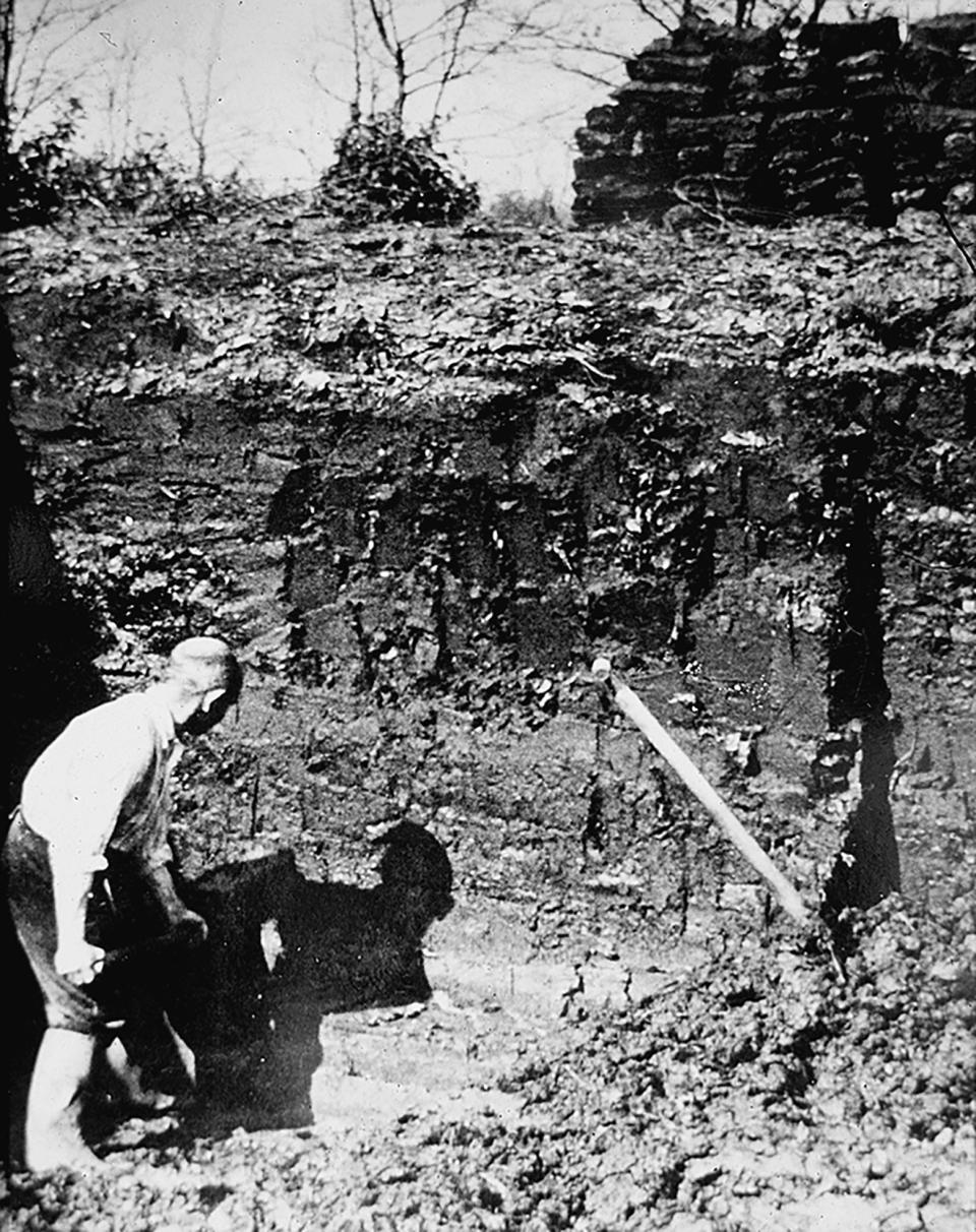 Oude zwartwitfoto van turfsteker die turf afgraaft
