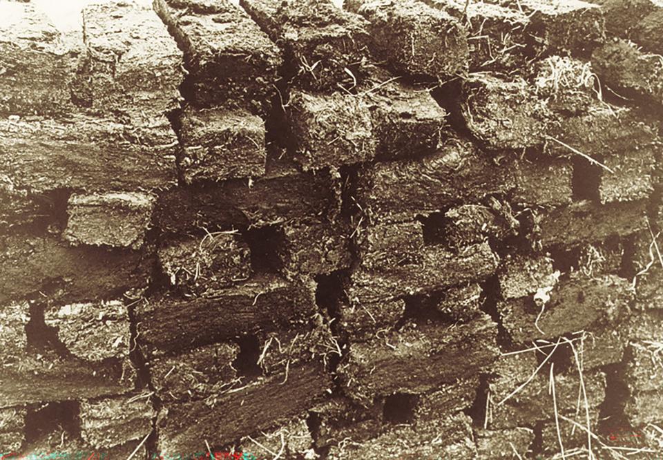 Oude zwartwitfoto van stapel turfblokken