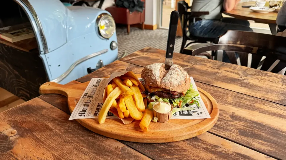 Tafel met plank met frietjes en burger erop